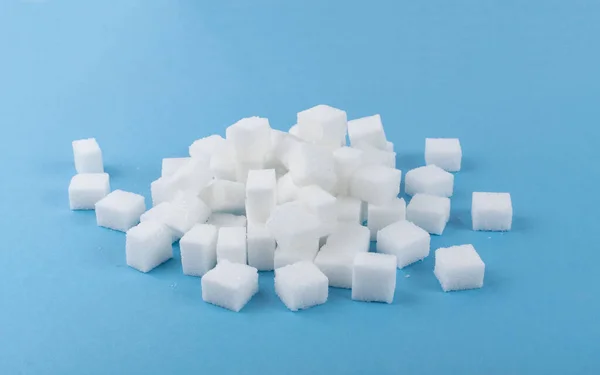 青の背景に白砂糖の立方体が孤立している 精製白砂糖キューブコレクションサイドビュー — ストック写真