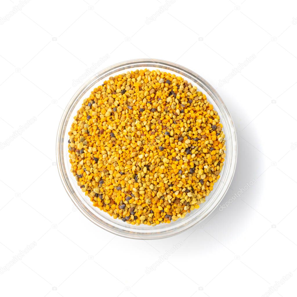 Pile of bee pollen or perga in glass bowl isolated on white background top view. Raw brown, yellow, orange and blue flower pollen grains or bee bread heap. Healthy food supplement