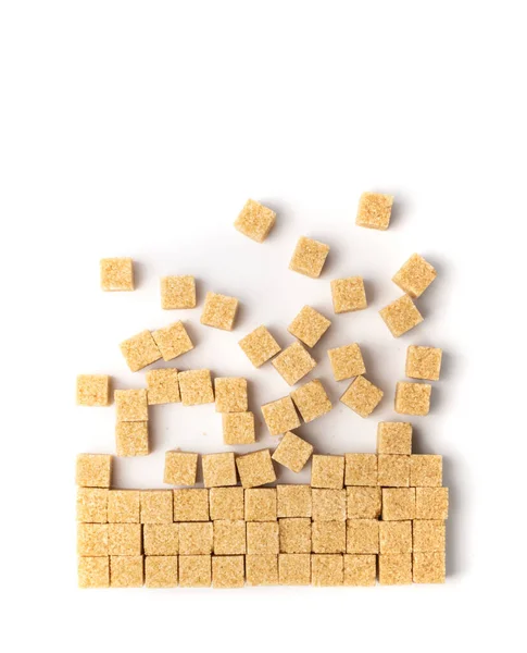 Raw brown sugar cubes isolated on white background flat lay. Unrefined cane sugar square pixels texture pattern top view
