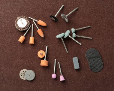 Zımpara aleti için cilalama araçları ayarlandı. Parlatıcı tekerlekleri olan mini matkap aksesuarları, aşındırıcı diskler, zımpara kağıtları, zımpara aleti koleksiyonu, zümrüt kağıt, küçük aşındırıcı ekipmanlar.