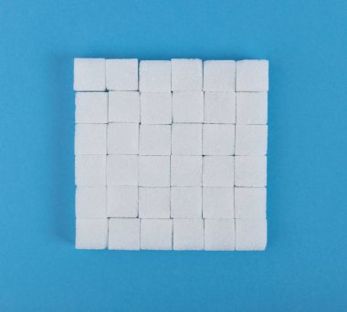 Beyaz şeker küpleri mavi arkaplanda. Rafine şeker küpleri kopya alanı ile üst görünüm modellemesi