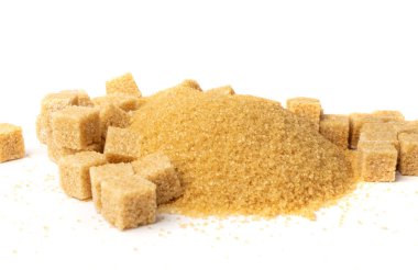 Esmer şeker, kum ve küp beyaz arka planda izole edilmiş. Rafine edilmemiş kamış şeker yığını yan görünüm