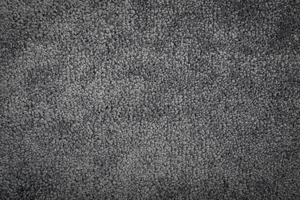 Gray carpet texture background top view. Dark grey nylon carpeting or mat pattern, nylon doormat wallpaper. Soft polyester carpet rug mockup with copy space