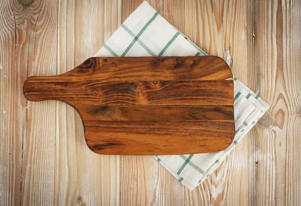 Old wood cutting board with a rustic napkin mockup. Vintage chopping board background with copy space top view