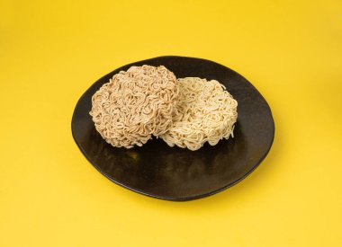 Çiğ Şehriye, Kara Tabakta Kuru Ramen Eriştesi, Pişmemiş Kore Vermicelli, Hızlı Çin Buğday Makarnası, Sarı Arkaplan 'da Anında Makarna