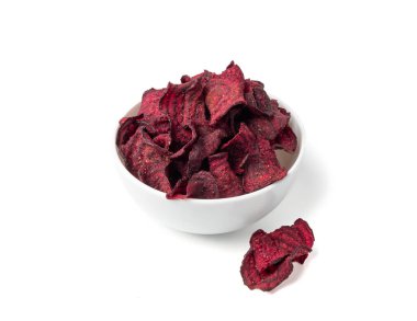 Kuru pancar cipsleri izole edilmiş, dilimlenmiş kırmızı pancar gevreği yığını, pancar kökü parçaları ve cipsler, beyaz arka planda kurutulmuş bol yağda kızartılmış sebze kökü yığını.