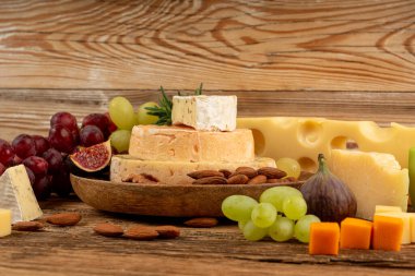 Peynir tabağı çeşitliliği, sarı, beyaz ve mavi gorgonzola tabağı, Munster, dört peynirli pano, çeşitli doğranmış süt ürünleri, ahşap üzerinde kokulu Fransız peyniri.