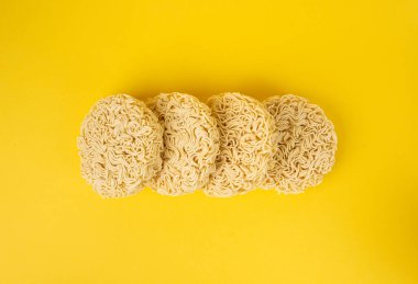 Çiğ Erişte Yığını, Kuru Yuvarlak Ramen Eriştesi Seti, Pişmemiş Kore Vermicelli, Hızlı Çin Buğday Makarnası, Sarı Arka plan Üst Görünümü Anında Makarna