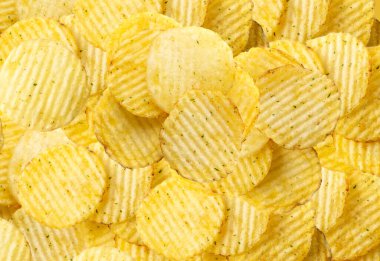 Kabartmalı cips, duvar kağıdı desenli arka plan, dalgalı patates cipsi deseni, çıtır çıtır atıştırmalık şablonu. Çırpılmış cips üst görünümü
