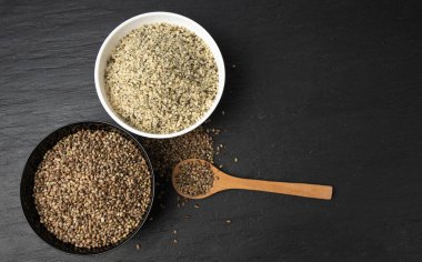 Kabuklu kenevir tohumları, soyulmuş kenevir taneleri, kabuksuz marihuana çekirdekleri, siyah arka planda yağlı protein kenevir tohumları.