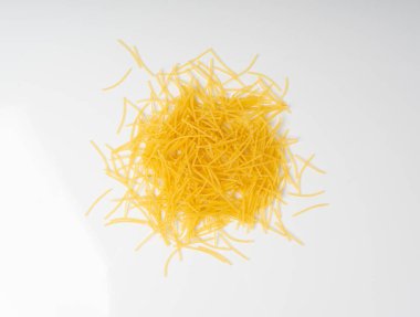 Çiğ vermicelli izole edilmiş, altın çorbalı makarna yuvarlak, küçük dağınık ev yapımı erişte, ince makarna, beyaz arka planda İtalyan filini makarna.