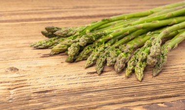 Ahşap Rustik Masaüstü 'nde bir demet Raw Garden kuşkonmazı. Taze Yeşil Bahar Sebzeleri, Yenilebilir Kuşkonmaz Resmi Yayları Kapatın