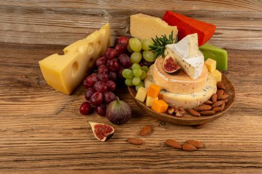 Peynir tabağı çeşitliliği, sarı, beyaz ve mavi gorgonzola tabağı, Munster, dört peynirli pano, çeşitli doğranmış süt ürünleri, ahşap üzerinde kokulu Fransız peyniri.