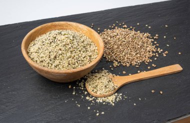 Kabuklu kenevir tohumları, soyulmuş kenevir taneleri, kabuksuz marihuana çekirdekleri, siyah arka planda yağlı protein kenevir tohumları.