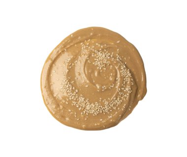 Tahini yuvarlak smear izole edilmiş, susam tohumu macunu sıçramış, tahina sosu dökülmüş, doğu sosu dökülmüş, geleneksel doğu mutfağı dairesel damla, zemin susamı beyaz arka planda.