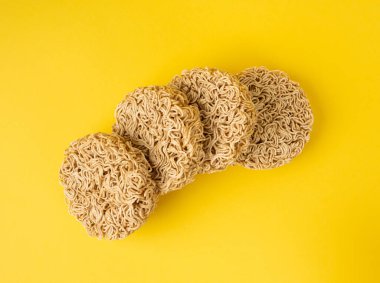 Çiğ Şehriye, Kuru Yuvarlak Ramen Erişte Seti, Pişmemiş Kore Vermicelli, Hızlı Çin Çavdar Buğday Makarnası, Sarı Arka plan Üst Görünümü Anında Makarna