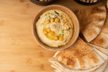 Tahta kasede humus, ev yapımı ev yapımı sos, nohut humus tahini sosu, orta doğu sosu, kırsal arka planda Arap humusu.