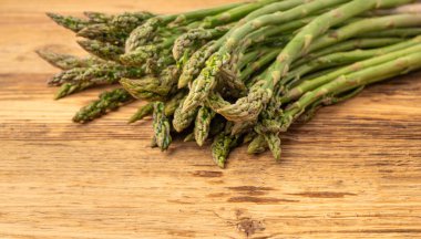 Ahşap Rustik Masaüstü 'nde bir demet Raw Garden kuşkonmazı. Taze Yeşil Bahar Sebzeleri, Yenilebilir Kuşkonmaz Resmi Yayları Kapatın