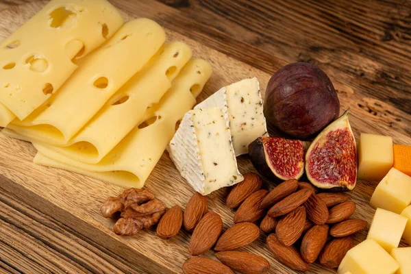 Peynir tabağı çeşitliliği, sarı, beyaz ve mavi gorgonzola tabağı, Munster, dört peynirli pano, çeşitli doğranmış süt ürünleri, ahşap üzerinde kokulu Fransız peyniri.