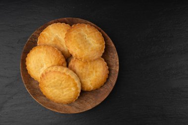 Hollanda geleneksel kurabiyeleri, Hollanda bademi dolgulu pasta, Hollanda badem ezmeli pasta, gevulde koek veya fındık ezmeli tart, siyah arka planda Breton tereyağlı bisküvi