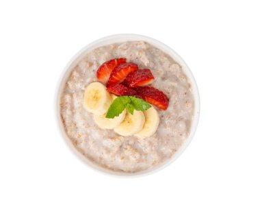 İzole edilmiş bir kasede pişirilmiş. Muz ve çilekli yulaf ezmesi sütlü yulaf lapası, haşlanmış emmer ya da keçeli mısır gevreği. Pişmiş buğday taneleri, meyveler ve müsli üst görünümü