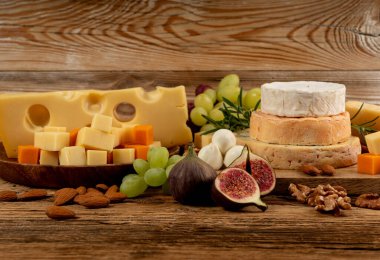 Peynir tabağı çeşitliliği, sarı, beyaz ve mavi gorgonzola tabağı, Munster, dört peynirli pano, çeşitli doğranmış süt ürünleri, ahşap üzerinde kokulu Fransız peyniri.