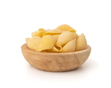 Çiğ konchiglionili makarna izole edilmiş. Kuru, kabuklu şehriye, büyük İtalyan makarnası, ahşap kasede buğday ezmesi, beyaz arka plan.