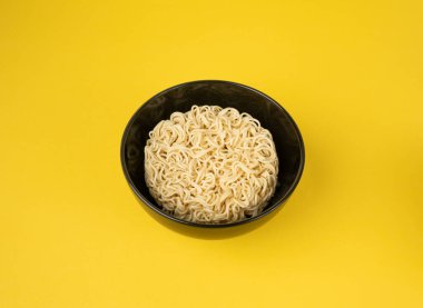 Çiğ erişte, yuvarlak Ramen Eriştesi Kasede, pişmemiş Kore Vermicelli, Hızlı Çin Buğday Makarnası, Sarı Arkaplanda Anında Anında Makarna