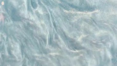 Mavi metalik gradyan, şampuan dokusuna benzeyen pürüzsüz soyut dalgalar, kozmetik sıvı veya ışıldayan pullar efektli duman bulutları.