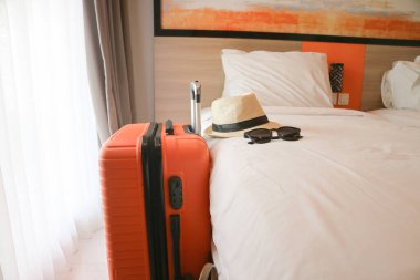 Hasır şapka ve güneş gözlüğü yatakta.