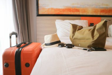 Otel odasında şapkalı seyahat valizi, yaz tatili konsepti.