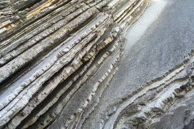 Katmanlı kayalar, sinek dokusu arka planı. Tortul kaya, çizgiler taş desen, başkalaşım bayrağı, doğa taşı duvar yapısı, eski kaba mineral oluşumu.