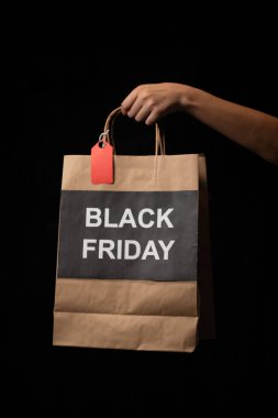 Siyah arka planda siyah bir el yazısı olan bir alışveriş çantası.
