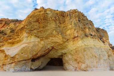 Bir kireçtaşı uçurumun Portimao Tres Castelos plajda altında bir mağara girişi. Algarve, Portekiz
