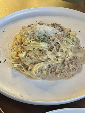 Lezzetli beyaz bir sosla kaplanmış kremalı ve zengin spagetti rahatlatıcı ve tatmin edici bir yemek için mükemmel bir lezzet sunuyor..