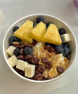 Doldurulmuş yoğurtlu tatlı bir fincanda servis ediliyor, pürüzsüz kremalı dokular, parlak yüzeyli, taze meyve parçaları ile kaplı, ferahlatıcı ve davetkar görünümünü detaylıca vurgulayan.