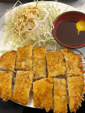 Çıtır tonkatsu, Japon usulü kızarmış domuz pirzolası dilimlenmiş lahana ve tuzlu sosla servis edilir. Lezzetli bir kıtır kıtır doku ve sulu et dengesi.