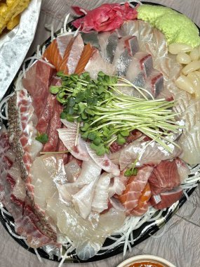 Taze ve narin sashimi dilimleri, canlı renkler ve mükemmel kesimlerle güzelce sunuluyor. Bu geleneksel Japon lezzeti kaliteli deniz ürünlerinin saf tatlarını vurgular..