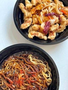 Zengin siyah fasulye sosuna bulanmış kalın, çiğnenmiş erişteli klasik Kore-Çin karışımı, yanında gevrek tangsuyuk, bol yağda kızartılmış domuz eti ve tatlı ve ekşi sos servis edilir..