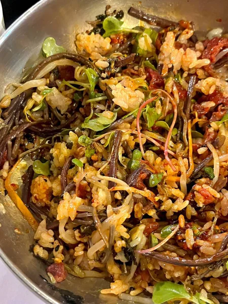 Bibimbap, çeşitli sebzeler, gochujang ve sıklıkla dilimlenmiş etin eşlik ettiği kızarmış yumurta ile süslenmiş canlı bir Kore pirinç yemeği. Karıştırıldığında, aromalı ve dengeli olur..