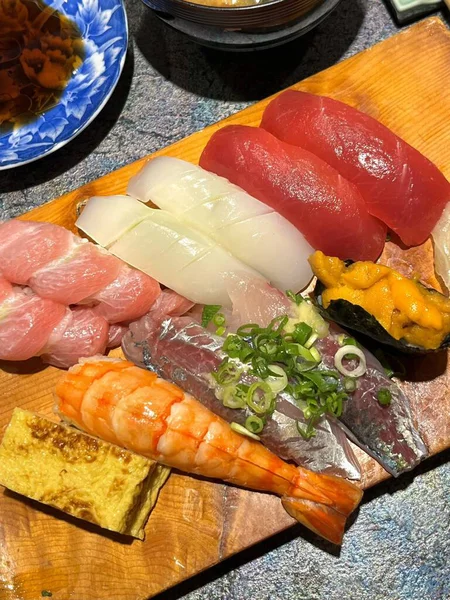 Çeşitli malzemeler ve canlı renklerle sanatsal olarak düzenlenmiş taze suşi çeşitleri. Bu geleneksel Japon yemeği bir deneyim için sirkeli pirinç, deniz ürünleri ve sebzeleri birleştirir..