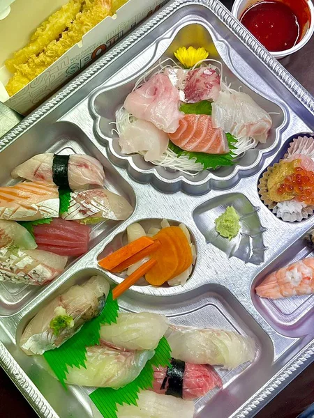 Taze ve narin sashimi dilimleri, canlı renkler ve mükemmel kesimlerle güzelce sunuluyor. Bu geleneksel Japon lezzeti kaliteli deniz ürünlerinin saf tatlarını vurgular..