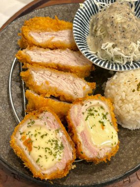 Çıtır tonkatsu, Japon usulü kızarmış domuz pirzolası dilimlenmiş lahana ve tuzlu sosla servis edilir. Lezzetli bir kıtır kıtır doku ve sulu et dengesi.