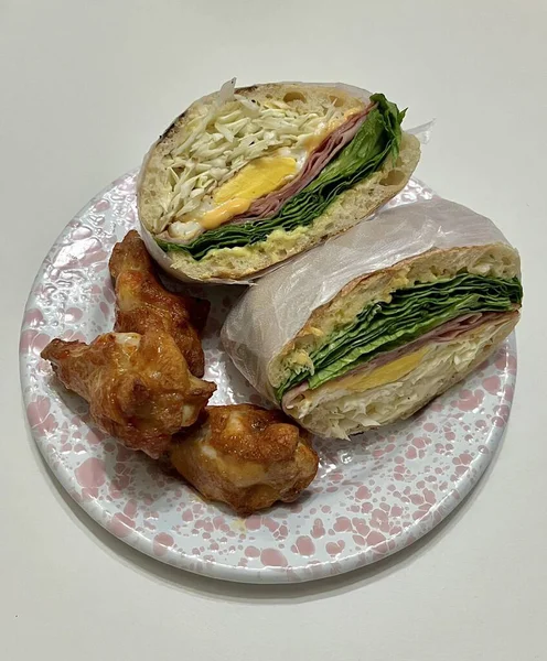 Çıtır sebzeler, taze etler ve iki dilim yumuşak ekmek arasında baharatlı yayılan baharatlı sandviçlerle dolu lezzetli bir sandviç. Hızlı ve tatmin edici bir yemek için mükemmel..