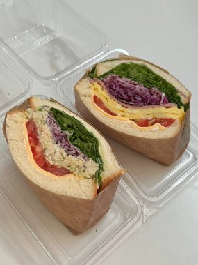 Çıtır sebzeler, taze etler ve iki dilim yumuşak ekmek arasında baharatlı yayılan baharatlı sandviçlerle dolu lezzetli bir sandviç. Hızlı ve tatmin edici bir yemek için mükemmel..