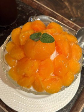 Refreshing bingsu, a Korean shaved ice dessert topped with sweet ingredients like red beans, fruits, and condensed milk. A perfect treat to cool down on hot days.