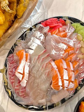 Taze ve narin sashimi dilimleri, canlı renkler ve mükemmel kesimlerle güzelce sunuluyor. Bu geleneksel Japon lezzeti kaliteli deniz ürünlerinin saf tatlarını vurgular..