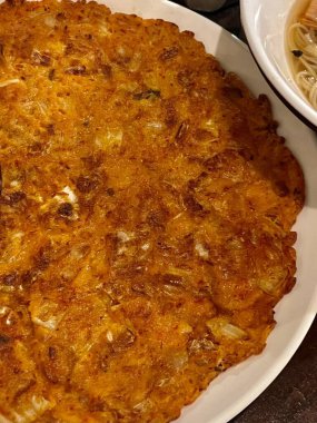 Altın-kahverengi gamja jeon, klasik bir Kore patatesli krep, dışı çıtır çıtır ve içi yumuşak. Basit ama lezzetli. Rahatlatıcı bir aperatif ya da her zaman yiyebileceğin bir meze..