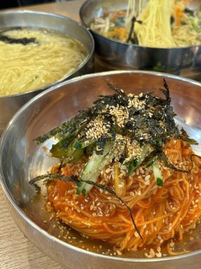 Soğuk ve ferahlatıcı Kore naengmyeon eriştesi, dilimlenmiş salatalık, turp ve haşlanmış yumurta ile servis edilir. Sıcak yaz günleri için nefis, keskin bir yemek..