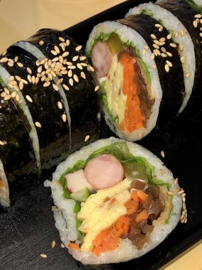 Taze sebzelerle, baharatlı pirinçlerle ve gevrek yosunlara sarılmış lezzetli proteinlerle dolu nefis kimbap dürümleri. Her ısırıkta lezzet ve dokuların mükemmel bir kombinasyonu.